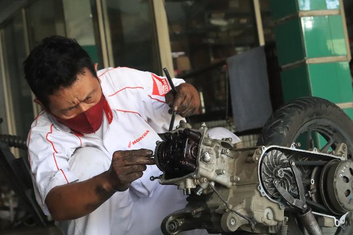 a man working on a motorcycle in a garage